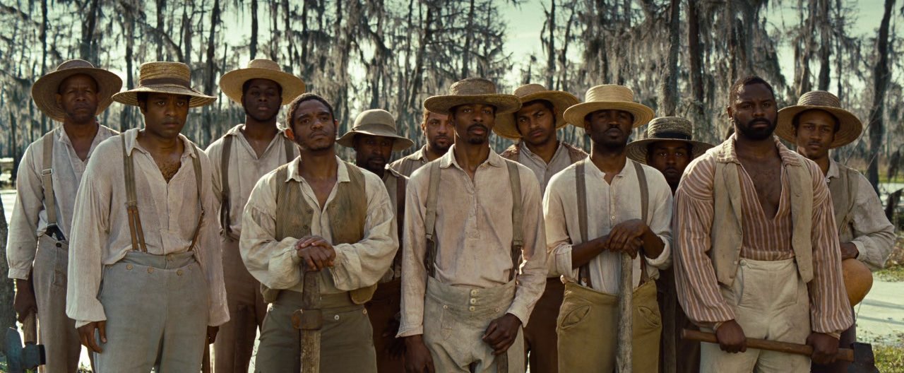 Film still from 12 Years a Slave (2013) showing 12 slaves stood in a group by British director Steve McQueen 
