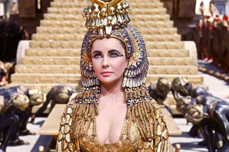 Cleopatra (1963) – Elizabeth Taylor on the elaborate Egyptian palace film set with gold costumes and Cinecittà Studios production design