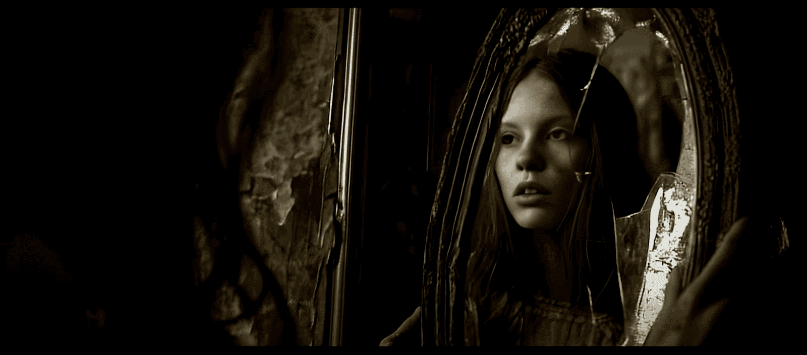 film still showing a girl looking into a broken mirror