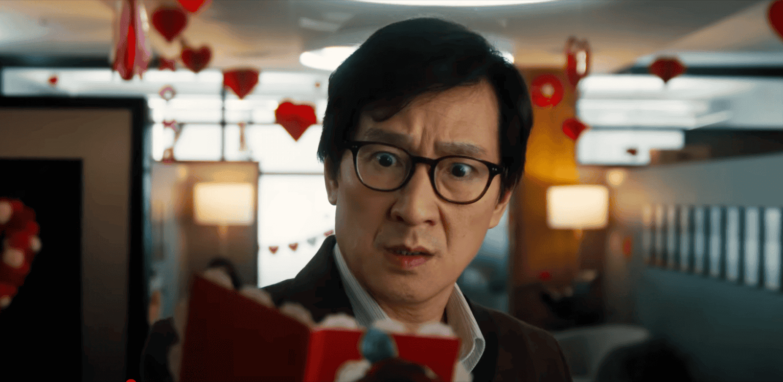 film still showing a man looking shocked at a notebook