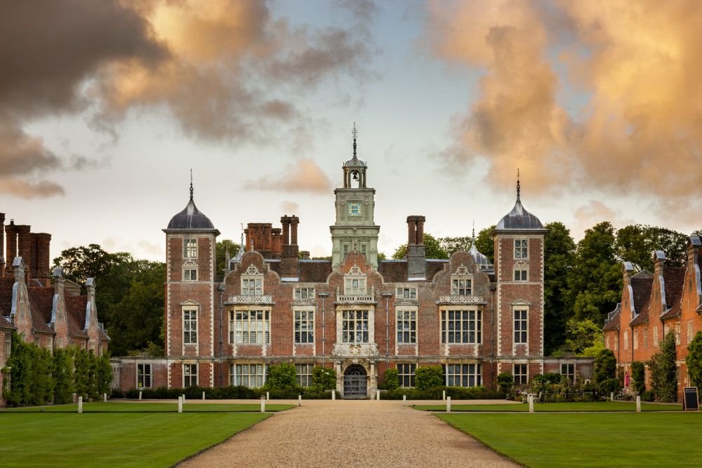 Jacobean manor house at golden hour with dramatic clouds over the Norfolk countryside
