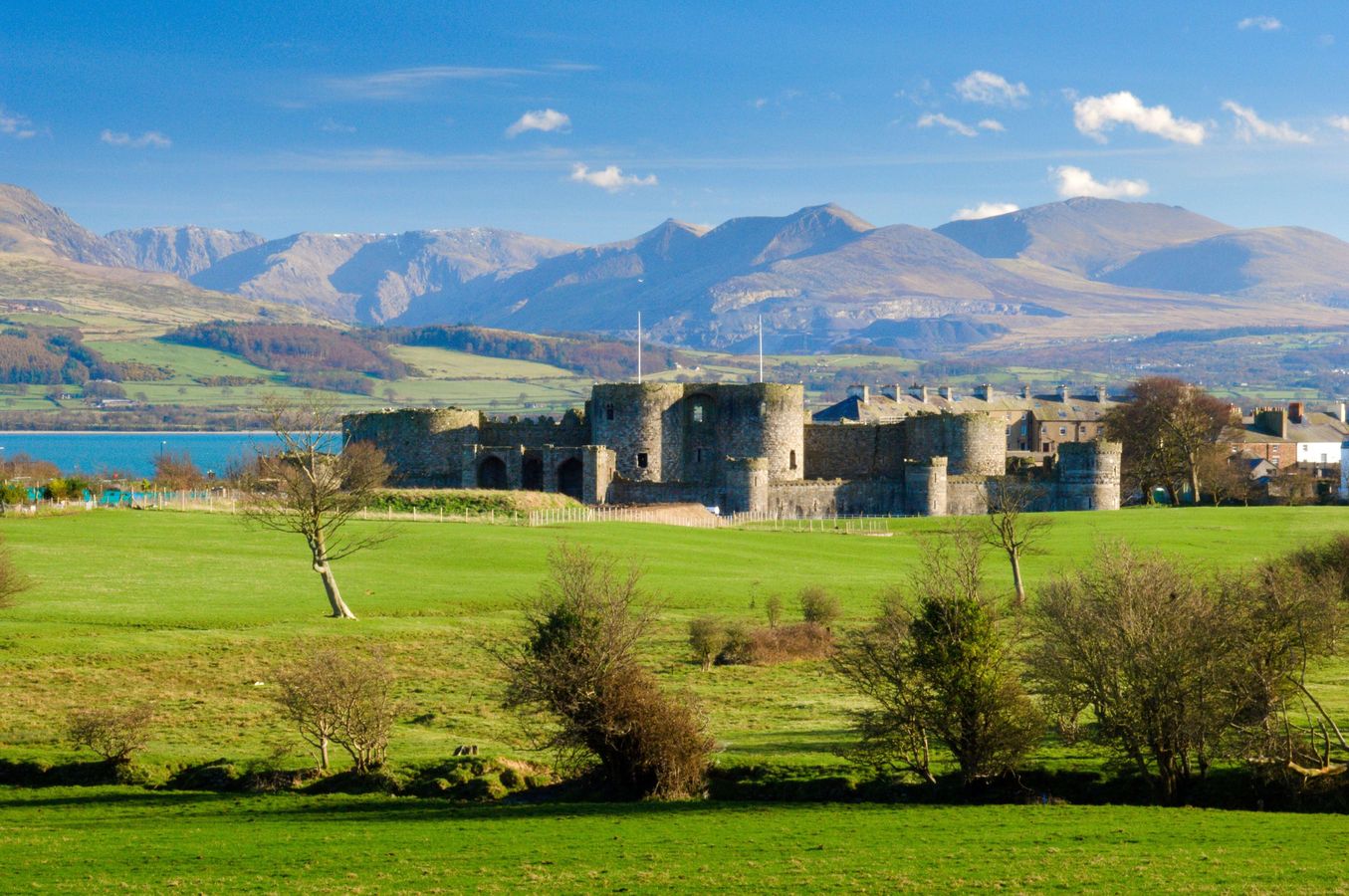 Beaumaris Castle on Anglesey with the Snowdonian mountains and Menai Strait in the background