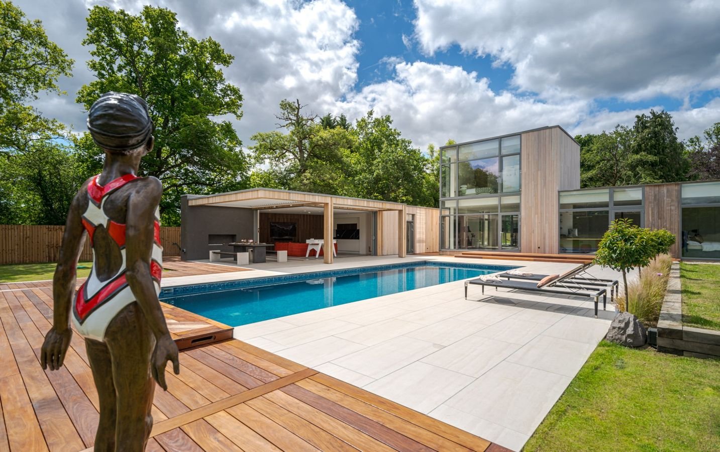 Contemporary luxury residence with swimming pool, bronze sculpture, and cedar-clad architecture in Surrey