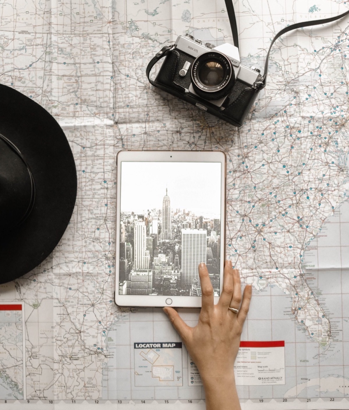 Filmmaker reviewing location scouting materials with camera and map spread on table