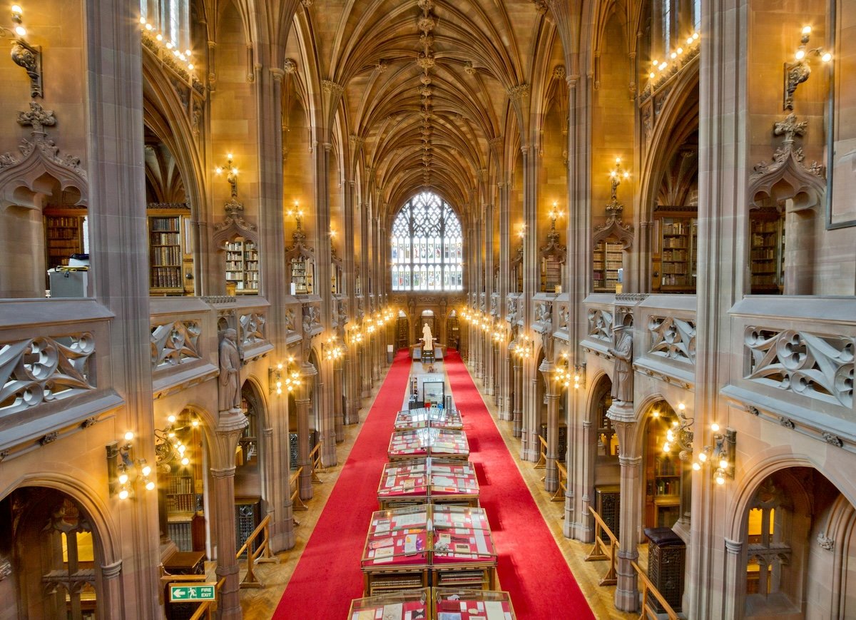 Long corridor with vaulted ceiling and stained glass window of John Rylands Library